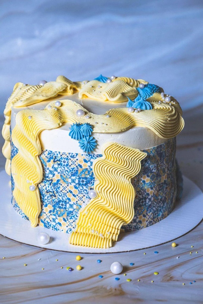 Mönstrad tårta med gula ribbonvågor och blå maränger